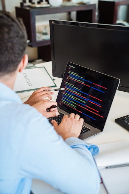 A detailed digital photograph of computer code featuring a mixture of colorful syntax highlighting, including multiple lines of HTML, JavaScript, and CSS scripting, displayed on a dark background. The